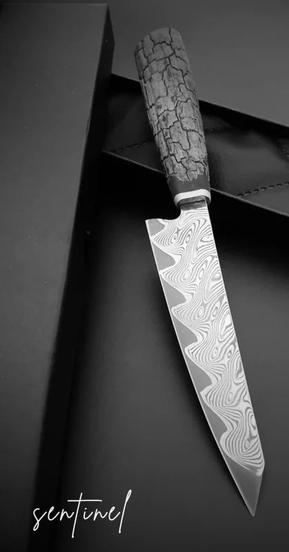 Frontalansicht des Federdamastmessers Evolution – markante Klingenform, symmetrischer V-Schliff und stilvoller Holzgriff
