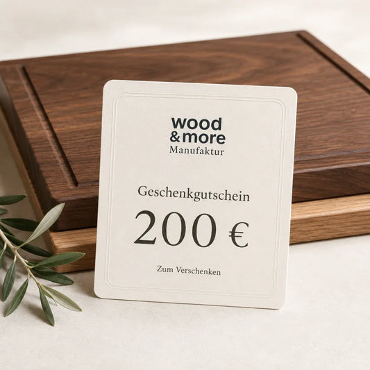 200 € Gutschein: wood & more Geschenkgutschein über 200 Euro mit massiven Holz-Schneidebrettern im Hintergrund