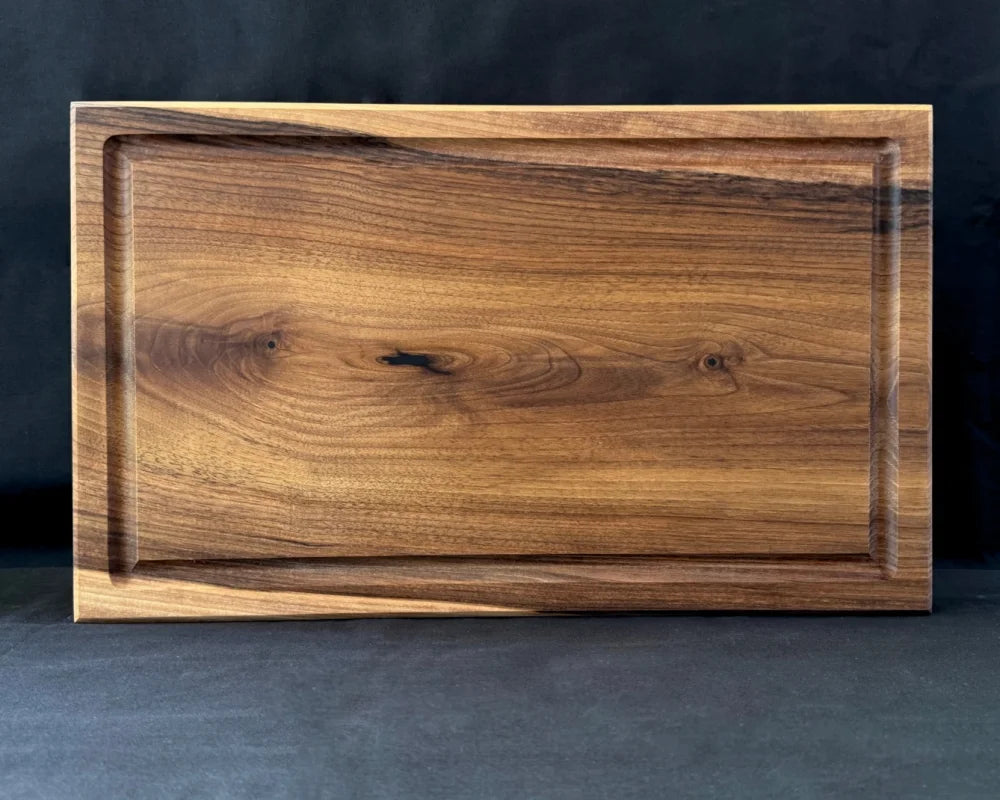 Massives Nussbaum-Schneidebrett 50 × 30 × 5 cm in frontaler Ansicht mit Saftrille und länglicher Arbeitsfläche