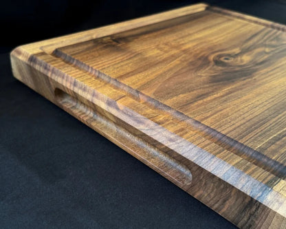 Seitliche Griffmulde am 5 cm starken Nussbaum-Schneidebrett 50 × 50 cm für einfaches Anheben und sicheres Tragen