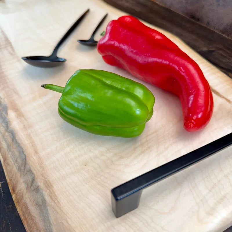 Frische rote und grüne Paprika auf einem Premium Schneidebrett Holz für die Küche